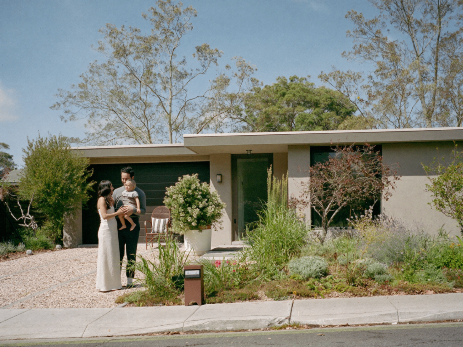 A young family in the front yard of their new home